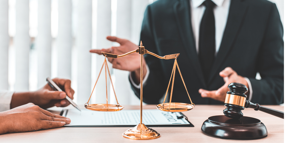 Deux mains posées à plat sur un contrat imprimé, stylo entre les doigts, pages annotées et agrafées